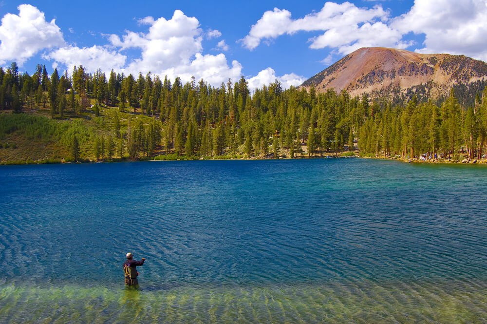 Photo of a person in Mammoth Lakes fishing next to mountain views